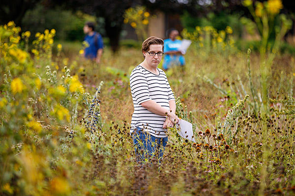 AMBS student Tyler Brinkman stands among the prairie grasses during the Leadership Education in Anabaptist Perspective course.